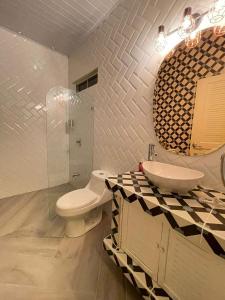 uma casa de banho com um WC, um lavatório e um espelho. em Hotel Villas Gaia Ecolodge em Uvita