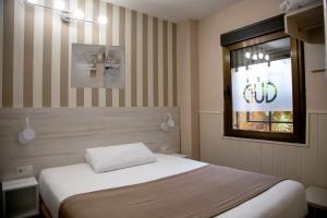 1 dormitorio con cama y ventana en Hostal Gud Salamanca, en Salamanca