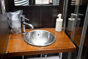 ein silbernes Waschbecken auf einer Holztheke im Bad in der Unterkunft Hostal Gud Salamanca in Salamanca
