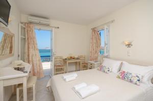 a bedroom with a bed and a view of the ocean at Orkos Blue Coast in Mikri Vigla