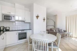 een keuken en een woonkamer met een witte tafel en stoelen bij La Terrasse de Mademoiselle in Versailles