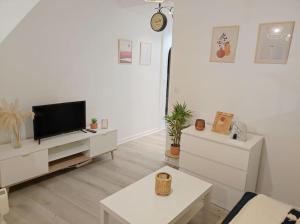 - un salon avec une télévision et une table dans l'établissement Charmant appartement avec terrasse proche Paris, à Le Perreux-Sur-Marne