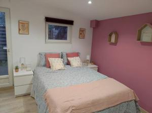 - une chambre dotée d'un lit avec un mur violet dans l'établissement Charmant appartement avec terrasse proche Paris, à Le Perreux-Sur-Marne
