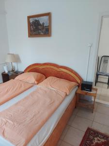 Malomtavi Vendégház في تابولتسا: سرير في غرفة نوم مع صورة على الحائط
