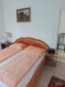 a bed in a bedroom with a picture on the wall at Malomtavi Vendégház in Tapolca