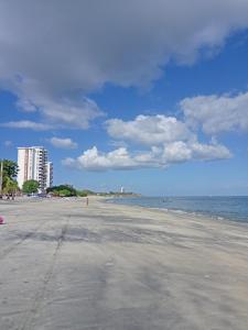 uma praia arenosa com edifícios e o oceano ao fundo em Kilian Beach House em Playa Blanca