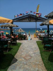 a walkway leading to a beach with tables and chairs at Dolphin Studios in Malia