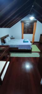 a bedroom with a bed and a wooden floor at Zef's Cottage in São Vicente