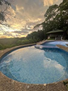 a large swimming pool with a sunset in the background at Hotel Villas Gaia Ecolodge in Uvita