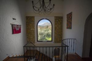 een kamer met een trap met een raam en een kroonluchter bij Casa Olea hotel rural in Priego de Córdoba