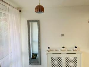 un espejo en una pared blanca junto a un armario blanco en Aylesbury Apartment for Contractors and Holidays en Aylesbury