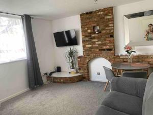 sala de estar con chimenea y TV en la pared en Aylesbury Apartment for Contractors and Holidays, en Aylesbury