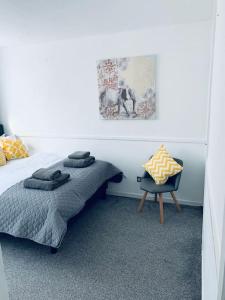 a bedroom with a bed and a chair in it at Aylesbury Apartment for Contractors and Holidays in Aylesbury