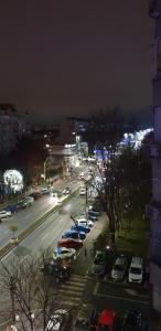 a city street at night with cars parked in a parking lot at Brancoveanu Apartament's in Bucharest