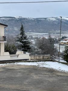 a house with snow on the ground next to a street at SantaRufinaHome in LʼAquila