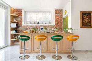 una cocina con taburetes verdes y naranjas en Ghe Sem Morazzone B&B, en Gazzada