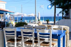 Ein blauer Tisch und Stühle vor dem Hintergrund des Ozeans in der Unterkunft Esperides Hotel in Paralia Agias Foteinis