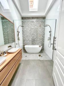 een badkamer met 2 wastafels en een bad bij Garden Cottage in Geelong