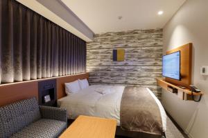 千葉市にある京成ホテルミラマーレのベッドとテレビ付きのホテルルーム