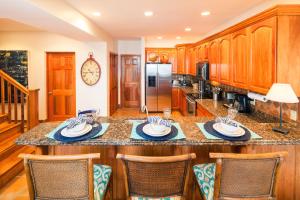 a kitchen with wooden cabinets and a large island with chairs at Coral Vista #4 - 50546 Home in West End