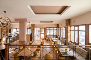 ein Esszimmer mit Tischen, Stühlen und Fenstern in der Unterkunft Esperides Hotel in Paralia Agias Foteinis