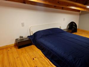 1 dormitorio con 1 cama con manta azul en Minicasa rural "El Sitio de la Vida" en Wanda