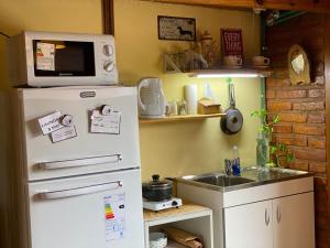 cocina con nevera blanca y fregadero en Nap Studio, un rincón cálido en El Calafate