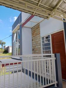 ein Haus mit einem weißen Zaun und einer Veranda in der Unterkunft azzima villa in Tlekung