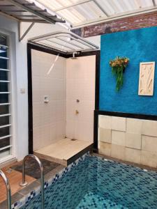 einen Pool mit einer Dusche mit blauer Wand in der Unterkunft azzima villa in Tlekung