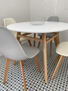 einen weißen Tisch und zwei Stühle auf einem karierten Boden in der Unterkunft Torreira Vacation Homes - Ria House in Torreira