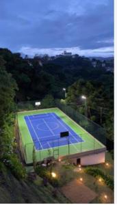 a tennis court is lit up at night at Carpe Diem Hotel Duplex in Campos do Jordão