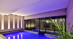 a swimming pool in a room with a purple ceiling at Carpe Diem Spa & boutique in Campos do Jordão