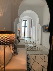 艾西拉的住宿－Asilah * Dar Badiaa * Riad vue sur l’Atlantique，一间带桌子的客厅和一间带沙发的房间