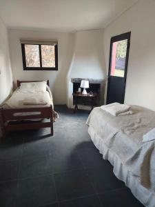 a bedroom with two beds and a piano in it at El Betete-Disfrute de la Sierra de las Animas in Pan de Azúcar