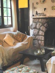 sala de estar con sofá y chimenea de piedra en El Betete-Disfrute de la Sierra de las Animas, en Pan de Azúcar