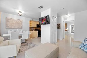 a living room with white furniture and a kitchen at Beautiful Apartment in the Heart of Miami Apt 3 in Miami