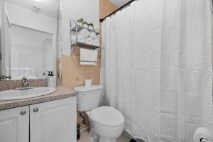 a bathroom with a toilet and a shower curtain at Beautiful Apartment in the Heart of Miami Apt 3 in Miami