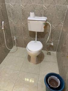 a bathroom with a toilet in a tiled wall at New Bungalow 2 Bed House in Adewumi, Off Olodo rd Ibadan in Ibadan