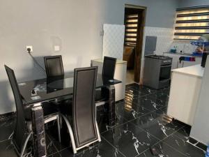 una oficina con un escritorio con sillas y una cocina en New Bungalow 2 Bed House in Adewumi, Off Olodo rd Ibadan, en Ibadán