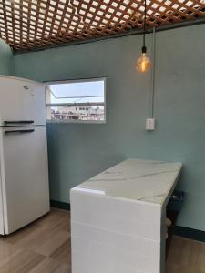 cocina con nevera blanca y encimera en Hostal Corazón de San Pedro en San Pedro La Laguna