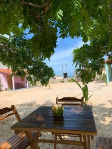 a wooden table with an apple sitting on top of it at Mar Aberto_chale 3 in Barroquinha