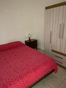 1 dormitorio con cama con colcha roja y cómoda en Edificio Aquarone 001, en Piriápolis