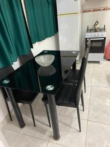 cocina con mesa negra y 2 sillas en Edificio Aquarone 001, en Piriápolis