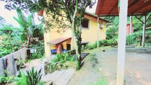 a house with a tree in front of it at Casas Jacatirão in Ubatuba
