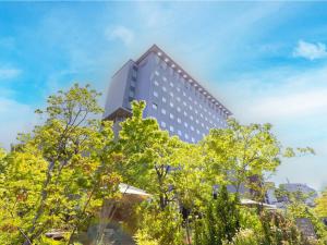a tall building with trees in front of it at KKR Hotel Hakata in Fukuoka