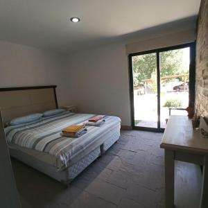 1 dormitorio con 1 cama y puerta corredera de cristal en Cabaña Ecologica en Uspallata