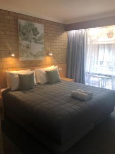 a bedroom with a large bed in a room at Muswellbrook Motor Inn in Muswellbrook