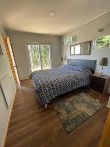 ein Schlafzimmer mit einem Bett und einem Teppich in der Unterkunft Cabañas Borde Lindo in Valdivia