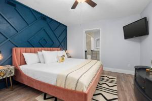 a bedroom with a large bed with a blue wall at Vintage Crown in Galveston