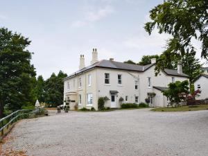een groot wit huis met een grindoprit bij Chestnut - 28866 in Stokeinteignhead
